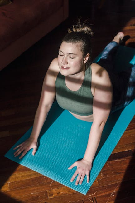 Serene woman in a comfortable yoga pose in a brightly lit room at sunrise